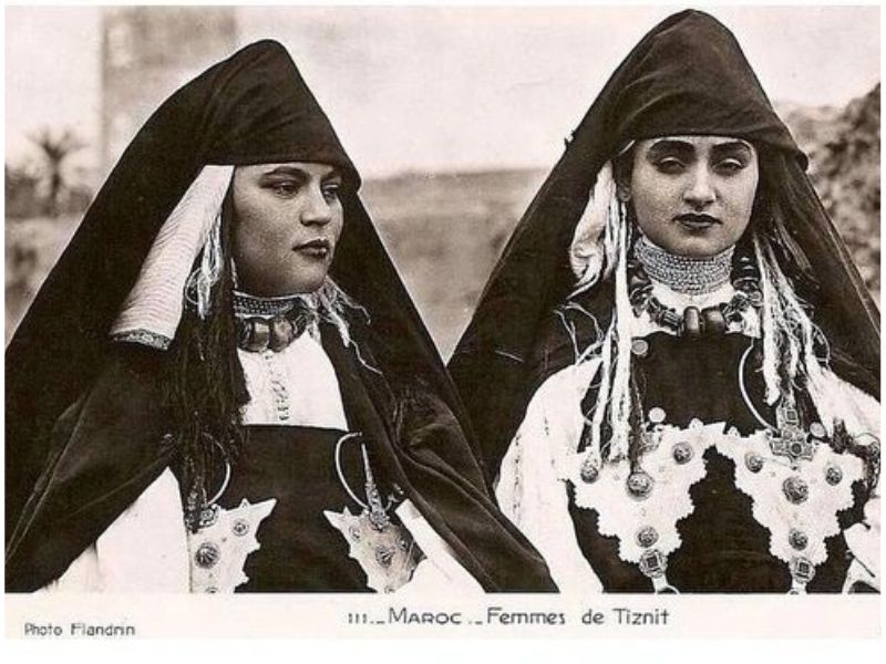 Two Amazigh women from Tiznit wearing traditional clothing and jewelry, showcasing cultural heritage.