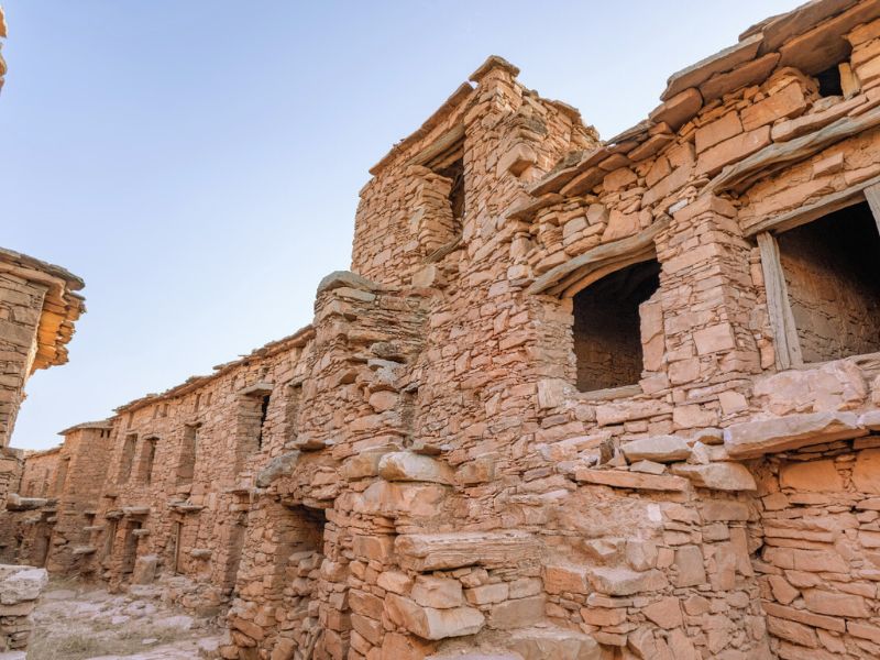 Ancient granary ruins in Morocco, showcasing traditional stone architecture, with multiple levels and windows, set against a clear sky.