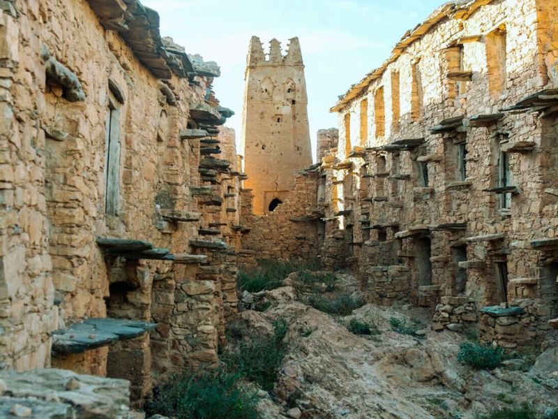Ancient granary structure in Igoudar, Morocco, showcasing stone walls, compartments for grain storage, and a prominent tower against a clear sky.