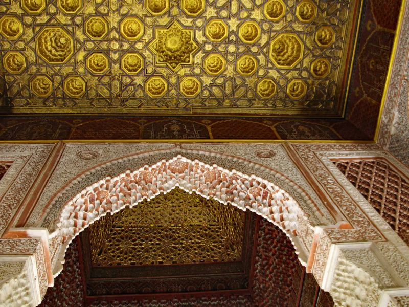 Intricate architectural details and ornate ceiling of a historical building, showcasing elaborate patterns and colors.