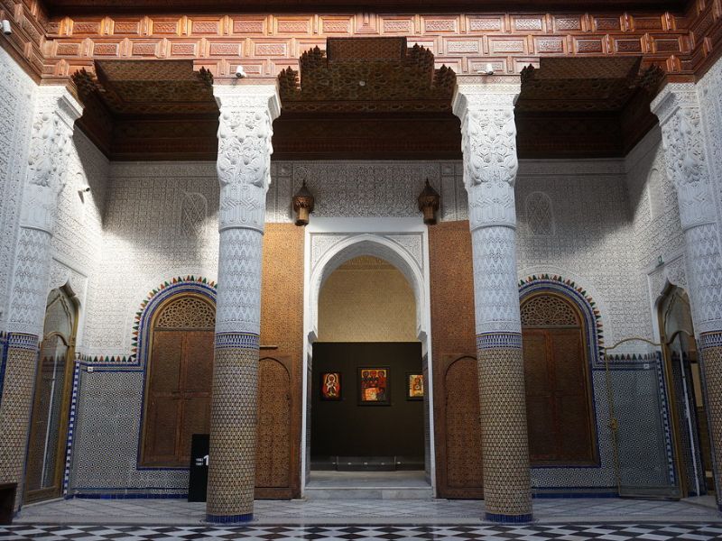 Interior view of Dar El Bacha – Musée des Confluences, showcasing intricately designed columns, ornate plasterwork, and traditional Moroccan architecture.