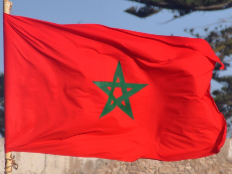 A close-up view of the flag of Morocco, featuring a red background with a green star in the center.