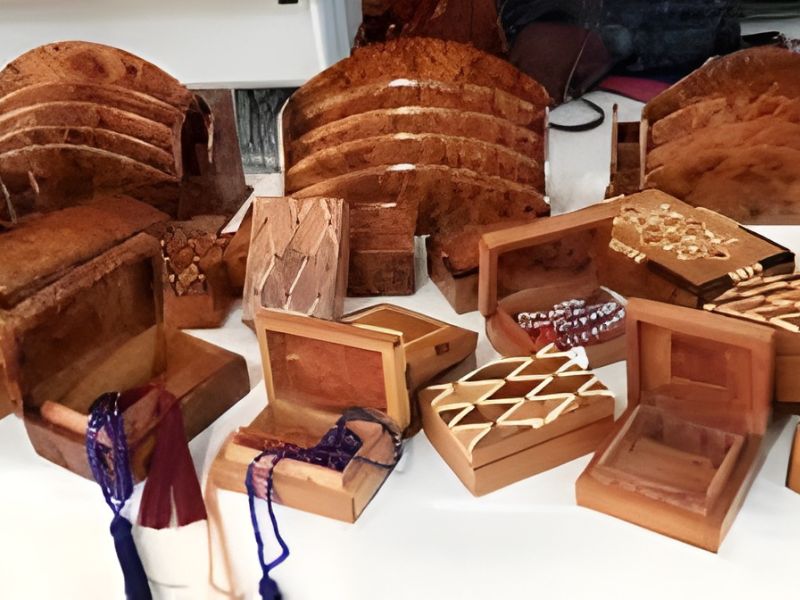 A collection of intricately designed wooden boxes in various shapes and sizes, some with decorative lids, displayed on a surface.