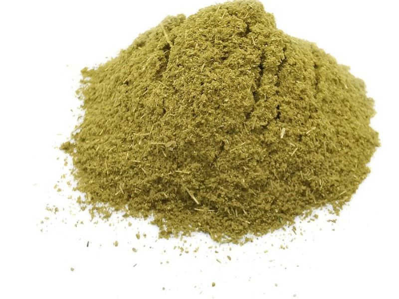 A mound of finely ground green powder, possibly a spice or herbal ingredient, with a textured surface.